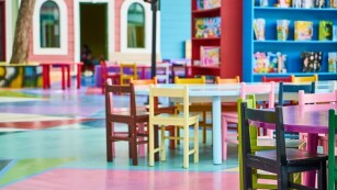 Zdjęcie przedstawia stolik i kolorowe krzesełka dla dzieci