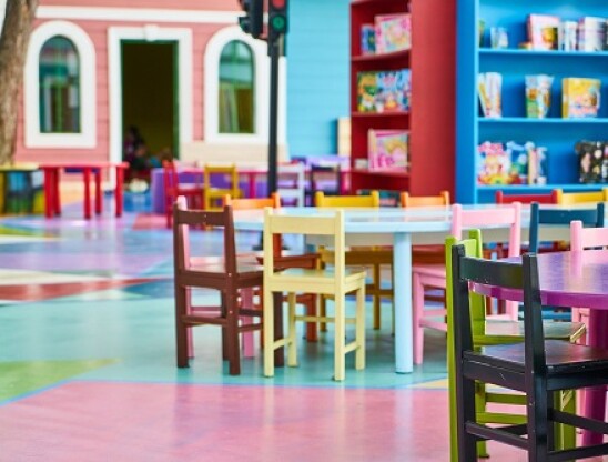 Zdjęcie przedstawia stolik i kolorowe krzesełka dla dzieci